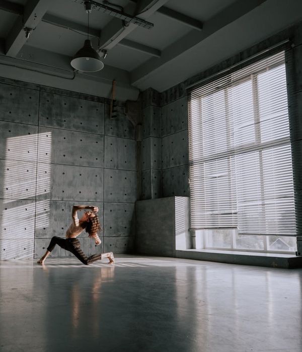 Woman performing a light cardio exercise in a minimalist studio.